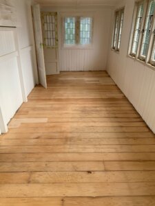 image of a lobby wooden floor repaired and sanded with natural light coming from side and front windows