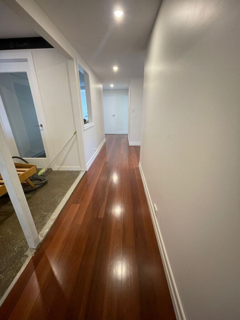 Polished timber corridor floor with a high-gloss polyurethane finish reflecting natural light