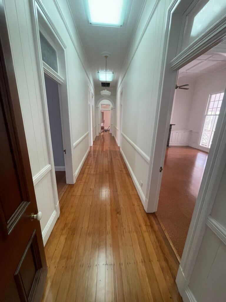 Long hallway featuring a satin polyurethane finish on restored timber floorboards for a modern look